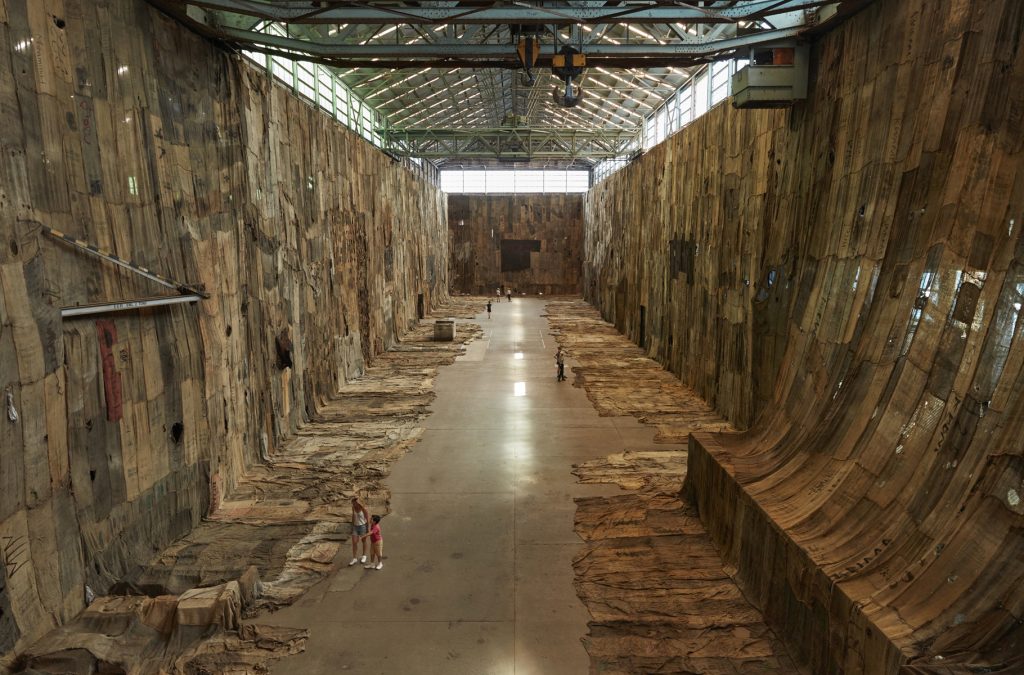 brahim Mahama, No Friend but the Mountains 2012-2020, 2020, charcoal jute sacks, sacks, metal tags and scrap metal tarpaulin, dimensions variable. Installation view (2020) for the 22nd Biennale of Sydney, Cockatoo Island. Courtesy the artist; White Cube; and 