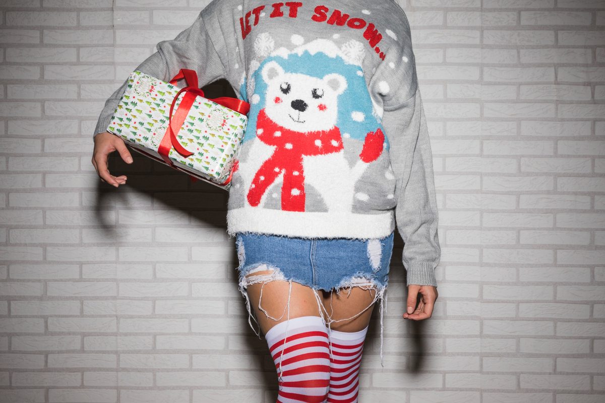 Woman in Christmas sweater with present