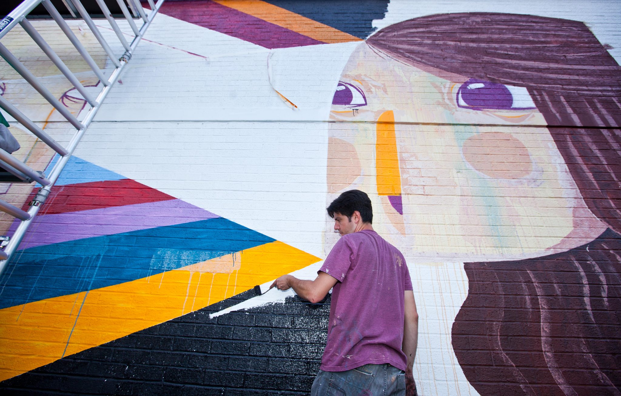 Brazilian Artist and Illustrator Caio Beltran works on his contribution at the UK's first bookable interactive art space in King's Cross, London June 18th, 2017. The giant public canvas is a wall of the Attic self-storage facility on York Way, and via a web app art lovers can vote for a piece to remain or be removed and repainted. Pic by Ben Gurr 