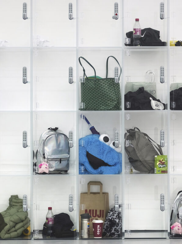 Something that 'is' versus something that ‘occurs’, 2023 Transparent lockers one might find in a museum, containing duplicated personal belongings for nine fictional personas, each replicated and identically arranged across two separate units. Acrylic lockers with different contents inside, bags, umbrella, items of clothing 2840 x 2000 x 355 mm © Ryan Gander; Courtesy the artist and Lisson Gallery. Photograph by Ryan Gander Studio