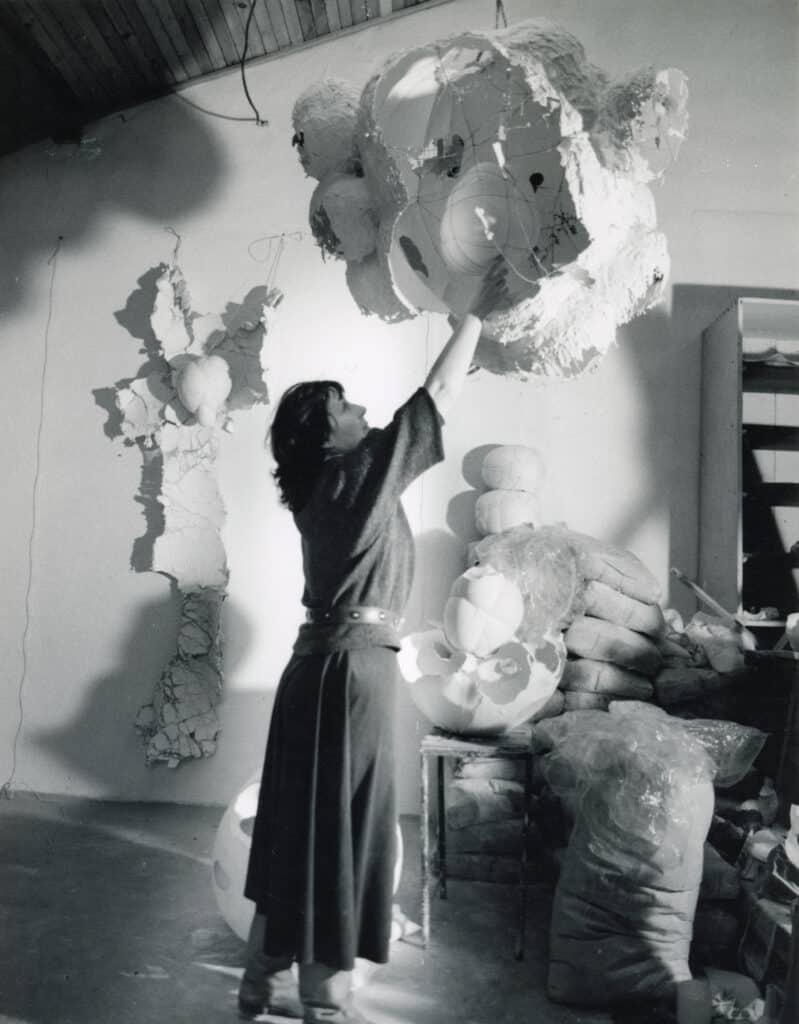 Maria Bartuszová in her studio with sculptures, 