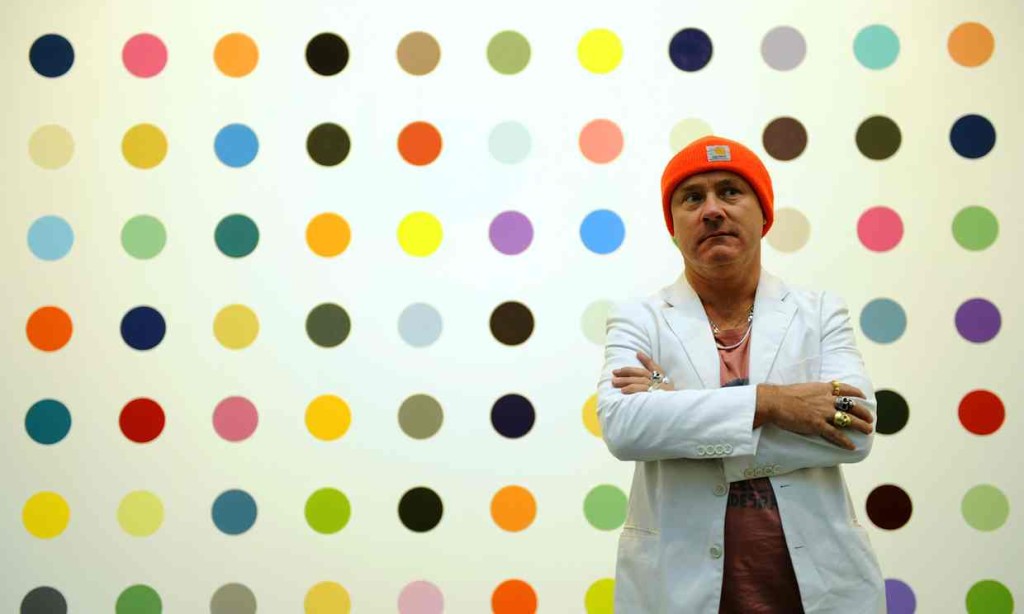 Damien Hirst in front of his dot paintings 