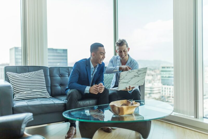 Two business professionals discussing examples of sales acceleration on a laptop