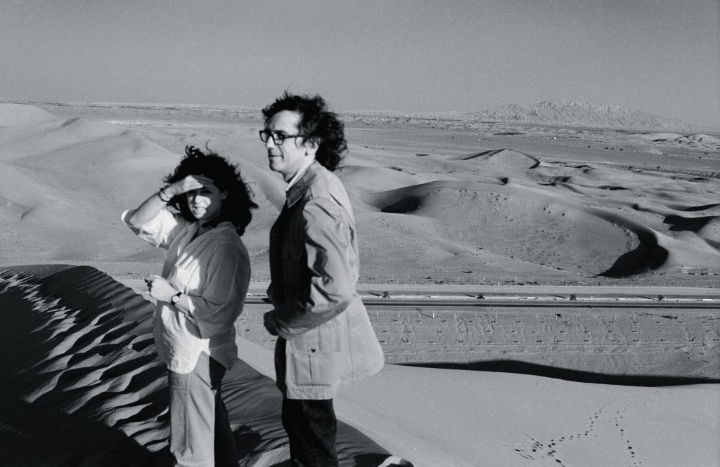 February 1979. Christo and Jeanne-Claude survey the desert from a dune in the UAE desert. Photo- Wolfgang Volz © 1979 Christo