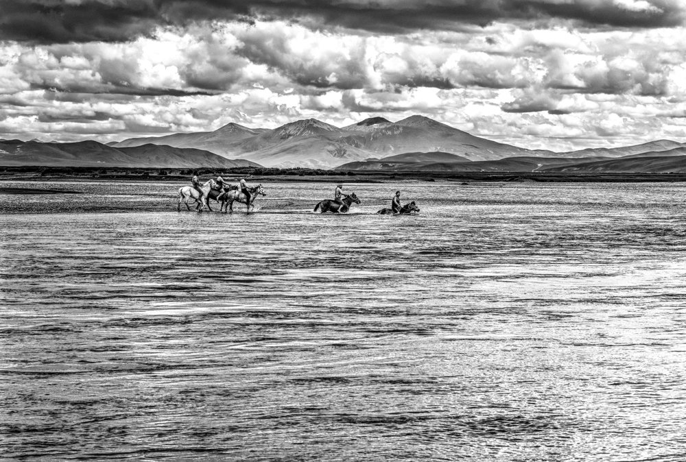 Traversée à la nage de la rivière Dzatchou (Mekong), près du monastère de Guémang, Dzatchoukha, Tibet oriental, Juillet 2016. Chaque été, dans la province de Dzachouka, à 4 000 m d’altitude au Tibet oriental, sont organisés des jeux et des courses de chevaux. Cette année, un groupe de cavaliers a décidé de traverser le fleuve Dzatchou, qui devient le Mekong lorsqu’il sort du Tibet, à cheval et à la nage. Après avoir pris les photos, je me suis moi-même baigné avec eux. L’eau était bien froide ! Swiming with horses accross the Dzachu river (Mekong) with horses. Dzachukha, Eastern Tibet, July 2016.