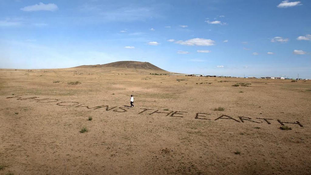 The Indian artist Vibha Galhotra was invited to make a site specific work for the 2016 Land Art Mongolia (LAM 360°) Biennial. Her work Who Owns the Earth? saw the question placed directly on the ground. The text was made of cow dung, a natural material found in the area. Her work addresses the fragile ecosystem found there, the nomadic culture of the people who live there and the threat due them because of climate change. Galhotra quotes Ban Ki-Moon “Already, hundreds of millions of people are facing increased hardships. Three quarters of all disasters globally are now climate related…” Who Owns the Earth? 2016 Istallation mixed media, 3 x 30 meters LAND ART MONGOLIA - 4th Biennial