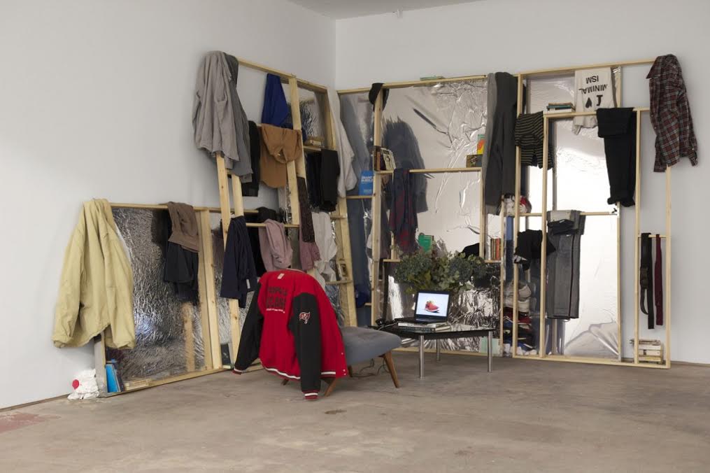 David Raymond Conroy, 2010 – 2014, 2015 Artist’s clothes, artist’s books, wood, privacy film, Parker Knoll chair, Le Corbusier LC4 table, vase, dried flowers Production and Marketing, 2014/15 Single channel HD video 7 mins FAD Magazine